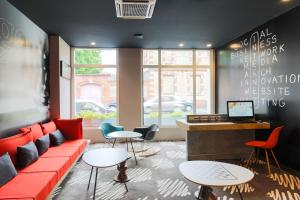 a living room with a red couch and tables at ibis Albi in Albi