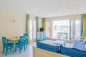 sala de estar con sofá, mesa y sillas en Residence Cap Hermes - maeva Home, en Fréjus