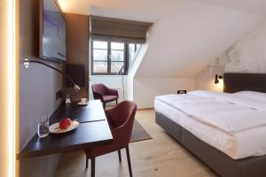 Hotel Gasthof zum Ochsen في أرليشايم: غرفة بالفندق سرير وطاولة مع صحن فاكهة