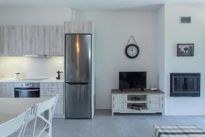a kitchen with a stainless steel refrigerator and a table at Evais Boutique Houses & Luxury Suites in Karistos