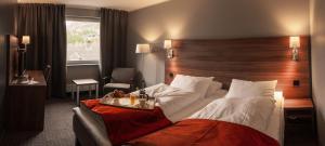 um quarto de hotel com uma cama grande e uma cabeceira em madeira em Thon Partner Hotel Otta em Otta