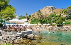 un gruppo di persone in acqua su una spiaggia di Hotel Kalithea a Calitea (Kallithea)