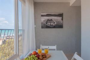 une table avec une assiette de fruits et des verres de jus d'orange dans l'établissement Dream On the Beach, à Haïfa