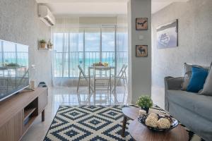 - un salon avec un canapé et une table dans l'établissement Dream On the Beach, à Haïfa
