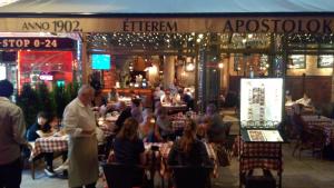 a group of people sitting at tables in a restaurant at City Center Rooms in Budapest