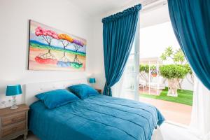 una camera con un letto blu e una grande finestra di Apartment Andrea ad Adeje Altre 48 foto