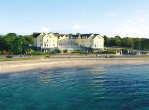 a large building on the beach next to the water at Galway Bay Hotel Conference & Leisure Centre in Galway