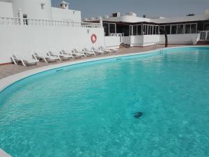 ein großes Schwimmbad mit Stühlen in einem Gebäude in der Unterkunft Bungalow Mariano 140 in Playa Honda
