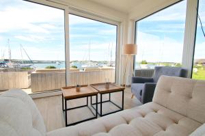 a living room with a couch and a large window at mönchgut living & spa in Gager