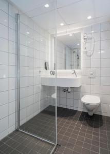 a bathroom with a shower and a toilet and a sink at Thon Hotel Tønsberg Brygge in Tønsberg