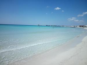 a beach with the ocean and people in the water at Casa Solemare in Torre Lapillo
