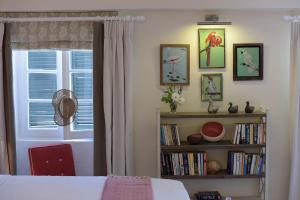 a bedroom with a book shelf and a window at Durrell Liston Suites in Corfu Town