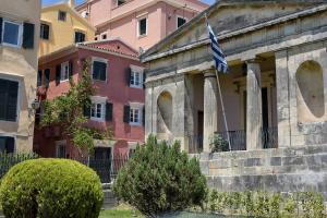 a building with a flag in front of it at Durrell Liston Suites in Corfu Town