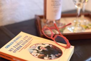 a book with a pair of glasses sitting on a table at Durrell Liston Suites in Corfu Town