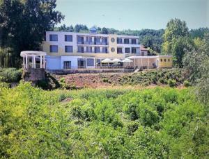 a large white building in the middle of a field at Хотелски комплекс Радецки град Козлодуй in Kozloduy