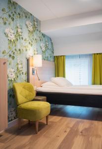 1 dormitorio con 1 cama y 1 silla amarilla en Thon Hotel Tønsberg Brygge, en Tønsberg