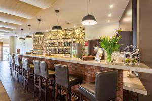 a bar with a row of bar stools at Hotel Wolin in Międzyzdroje