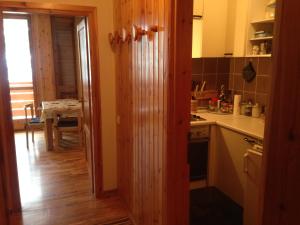 a kitchen with a door open to a dining room at Canazei Vacanze Dolomiti in Alba di Canazei