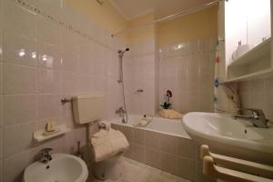a bathroom with a sink and a toilet and a tub at Petalo Bianco 100m from lake - Happy Rentals in Baveno