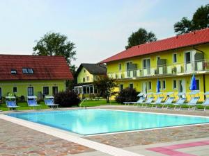 a hotel with a swimming pool in front of two buildings at Gasthof Zum Lindenhof in Bad Radkersburg