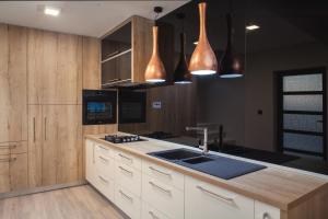 a kitchen with wooden cabinets and a sink and pendant lights at Villa Toni in Makarska