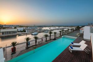 a pool on the roof of a building with a view of a harbor at Lagos Avenida Hotel in Lagos