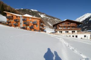 zwei Schatten von Menschen, die im Schnee vor einem Hotel spazieren in der Unterkunft Ferienhof Riml in Sölden
