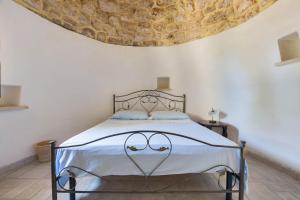 a bedroom with a large bed with a ceiling at Masseria Colosso by BarbarHouse in Patù