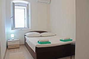 a bedroom with a bed with two towels on it at Apartment Tomislav in Zaostrog