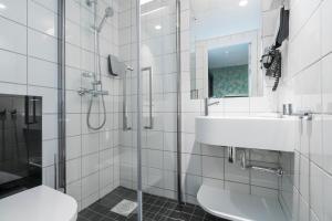 a white bathroom with a sink and a shower at Thon Hotel Nidaros in Trondheim
