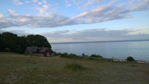 a red house on the shore of a body of water at Elisetorp in Kivik