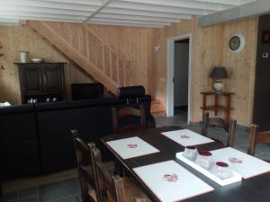 Gite d'Arbûmont في هيربيومونت: غرفة طعام مع طاولتين وأريكة