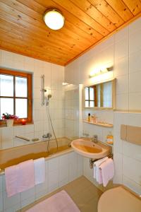 Un baño con bañera, lavabo y bañera. en Haus Christaldo, en Sankt Anton am Arlberg 28 fotos más