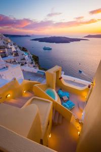 a view of the ocean from a resort at sunset at Alma Libre Suites in Fira