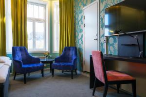 une chambre d'hôtel avec des chaises bleues, une table et un lit dans l'établissement Thon Hotel Nidaros, à Trondheim