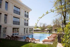 a hotel with a swimming pool with chairs and a building at The Escape Hotel in Ağva