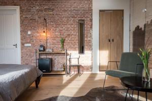 a bedroom with a brick wall and a bed and a tv at Loods Logement in Oost-Vlieland
