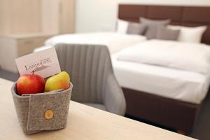 ポツダムにあるLandhotel Potsdamのホテルの部屋のテーブルにフルーツバスケットを用意しています。