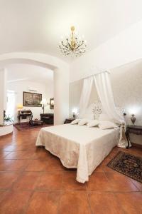 タルクイーニアにあるPalazzo Castelleschiのベッドルーム1室(白いベッド1台、シャンデリア付)