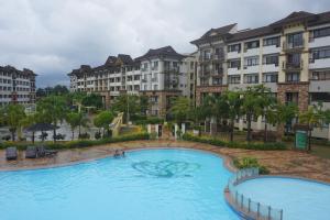 a pool at a resort with buildings in the background at Apartelle D' Oasis in Davao City