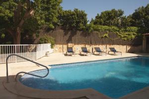 een zwembad met ligstoelen en een hek bij Villa Els Pins in Palma de Mallorca