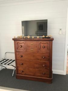 a wooden dresser with a television on top of it at Drayshed cottage in Blayney