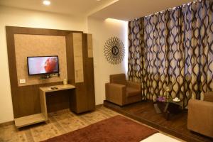 um átrio com uma sala de espera com uma televisão e uma cadeira em Hotel Alankar em Aurangabad