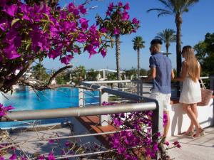a man and woman standing next to a railing near a pool at Regiohotel Manfredi in Manfredonia