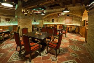 a restaurant with tables and chairs in a room at Halasi Pince Panzió in Villány