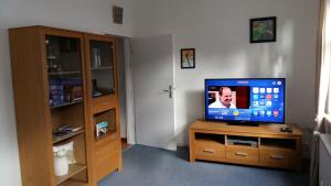 ein Wohnzimmer mit einem TV auf einem Holzständer in der Unterkunft Ferienwohnung am Nürburgring in Adenau
