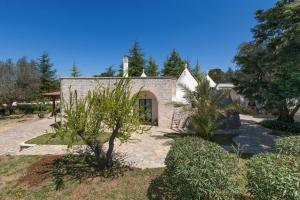a stone house with trees in front of it at Villa Ricci by BarbarHouse in Ceglie Messapica