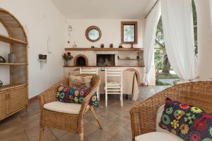 un soggiorno con sedie in vimini e camino di Villa Ricci by BarbarHouse a Ceglie Messapica