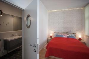 sypialnia z czerwonym łóżkiem i umywalką w obiekcie Houseboat Apartment w mieście Sopot