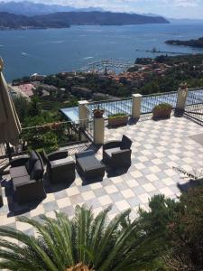 eine Terrasse mit Stühlen und Blick auf das Wasser in der Unterkunft Le Ville Relais in La Spezia